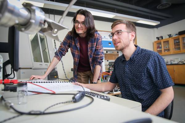 two students working in a lab at a computer