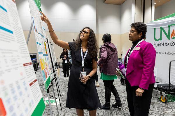 a woman giving a presenation to another woman in a suit